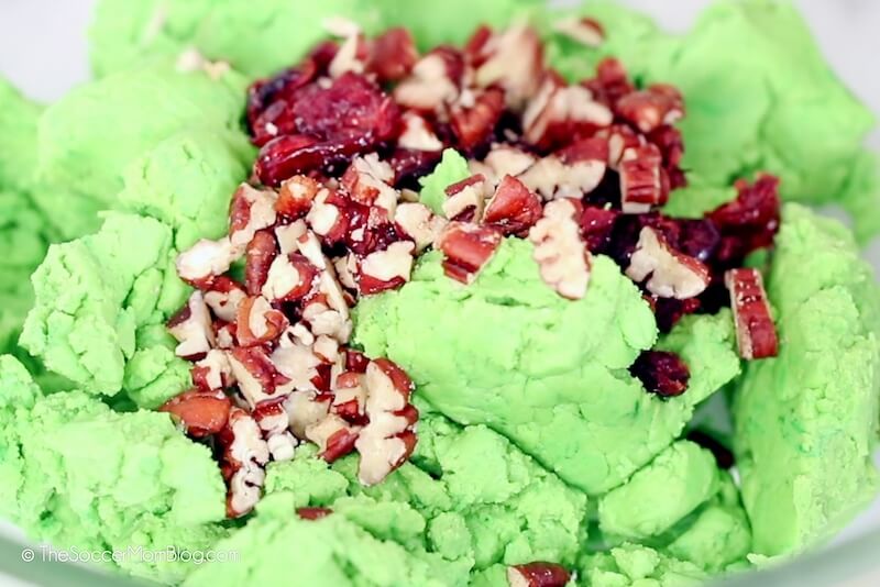 adding chopped pecans to green cookie dough