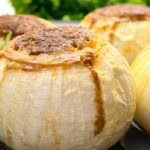close up of a stuffed onion bomb filled with ground beef and cheese.