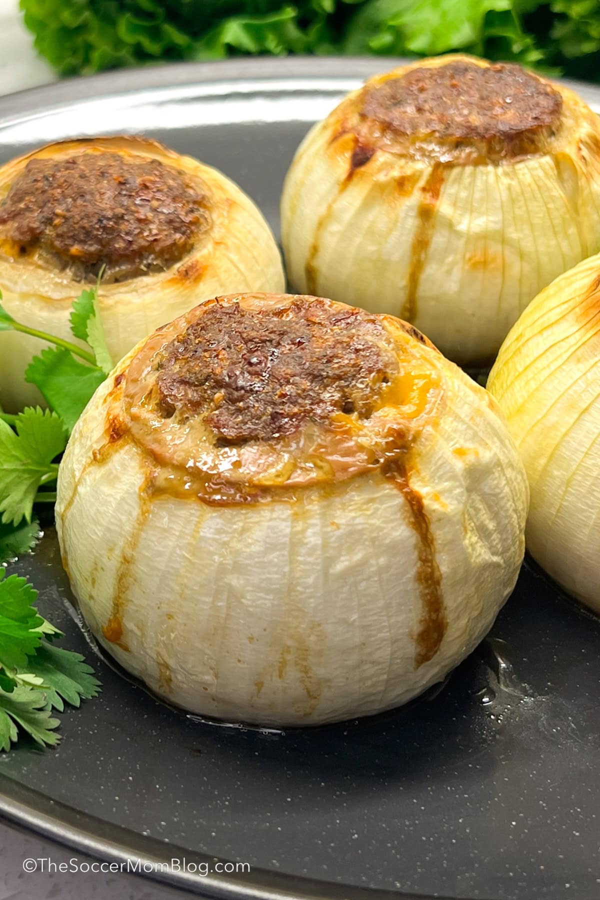 a plate of onion bombs stuffed with ground beef and melted cheese.