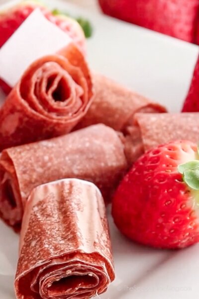 homemade strawberry fruit roll-ups on wooden surface