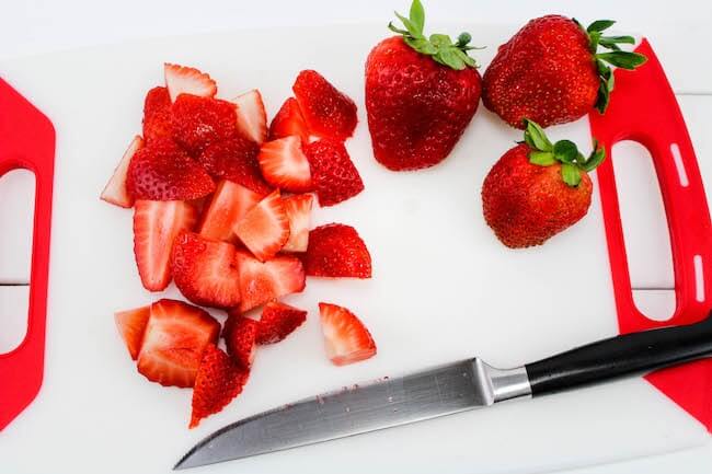 Chopping strawberries on cutting board