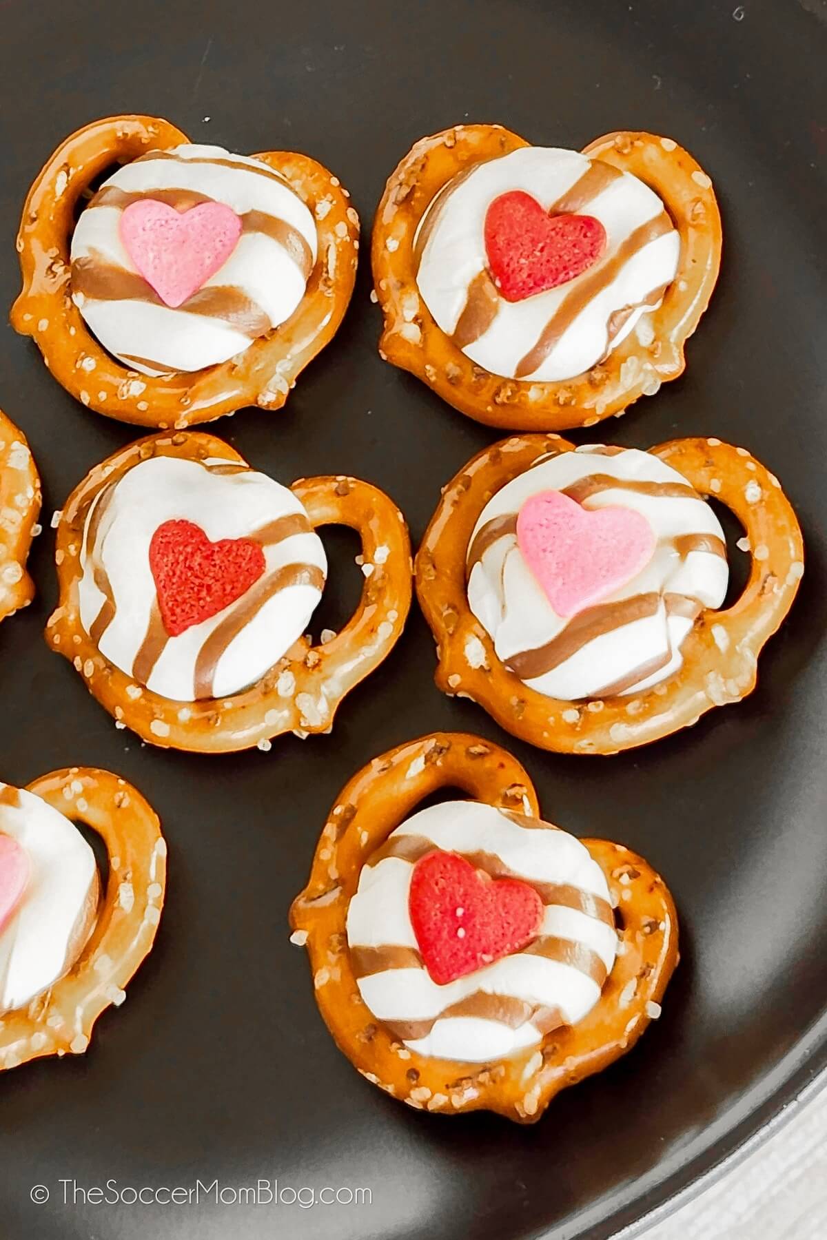 black plate with heart shaped candy covered pretzel bites