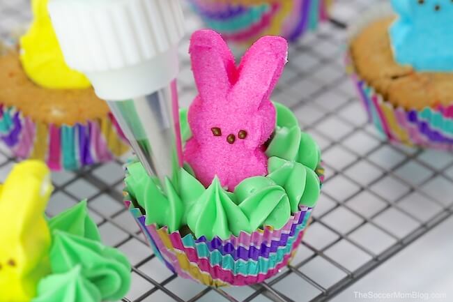 piping green frosting onto Peeps bunny cupcake