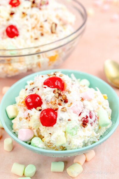 ambrosia salad in a small bowl with full bowl in background