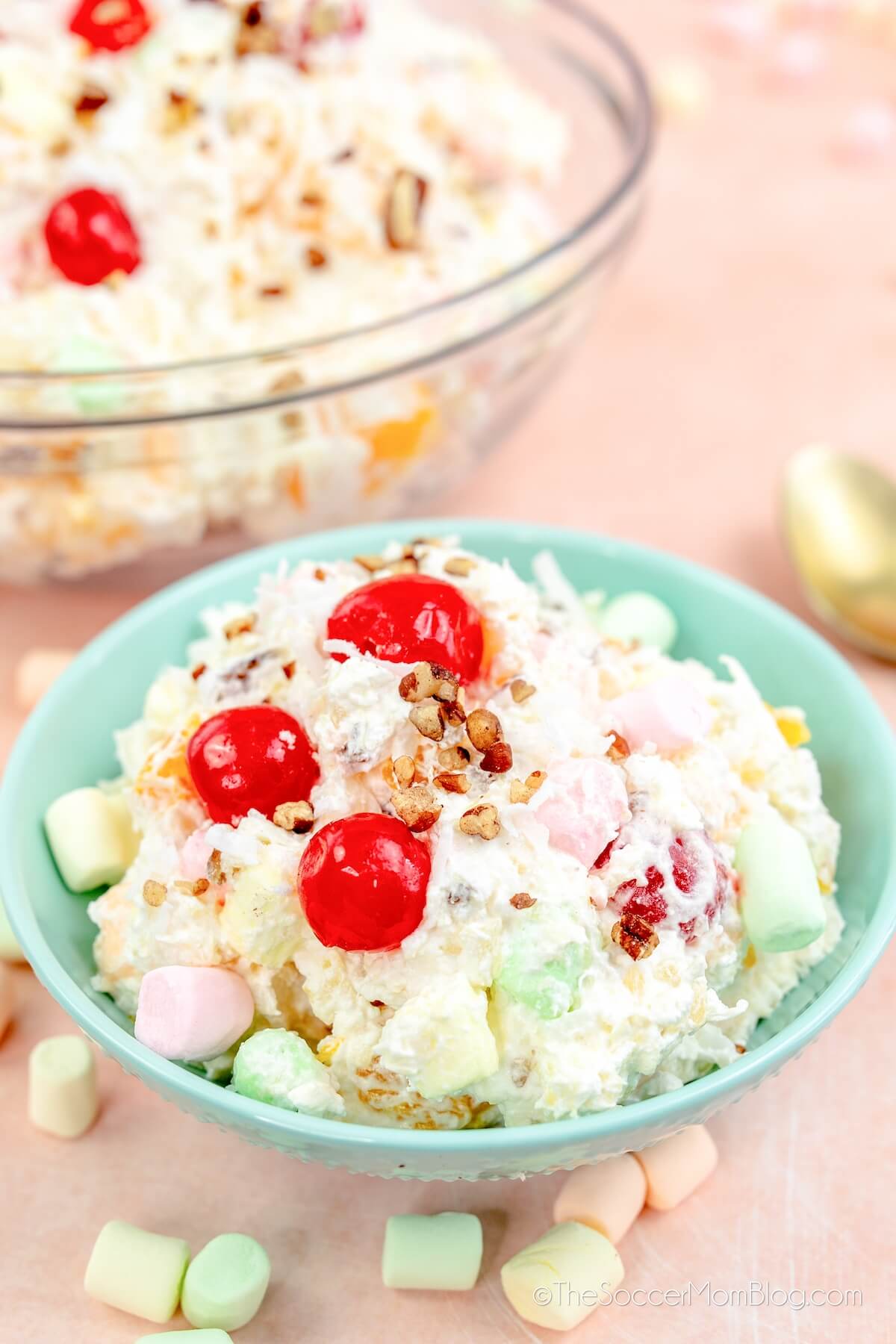 ambrosia salad in a small bowl with full bowl in background