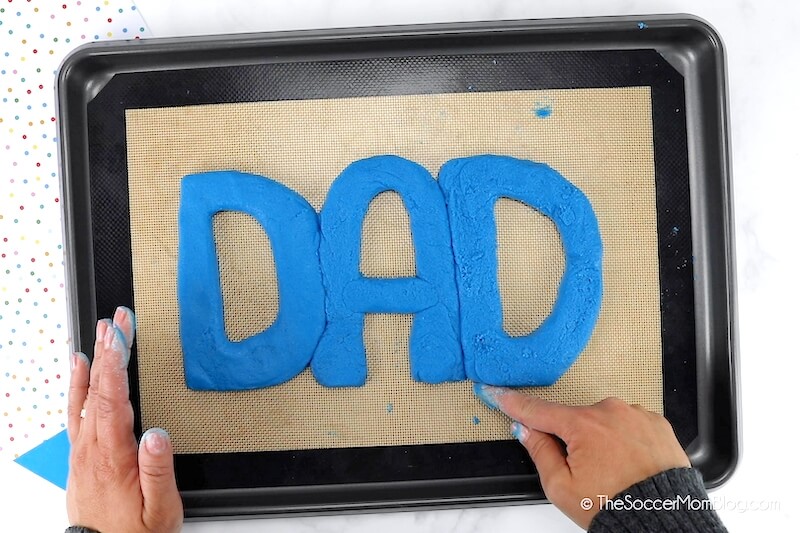 forming salt dough into letters that spell "DAD"