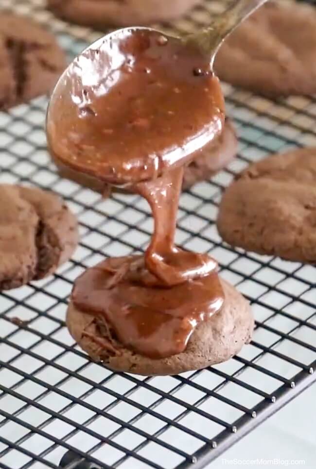 pouring chocolate icing over chocolate cookies