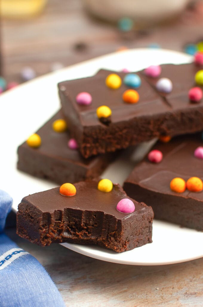 homemade Cosmic brownies on a plate, with one missing a bite.