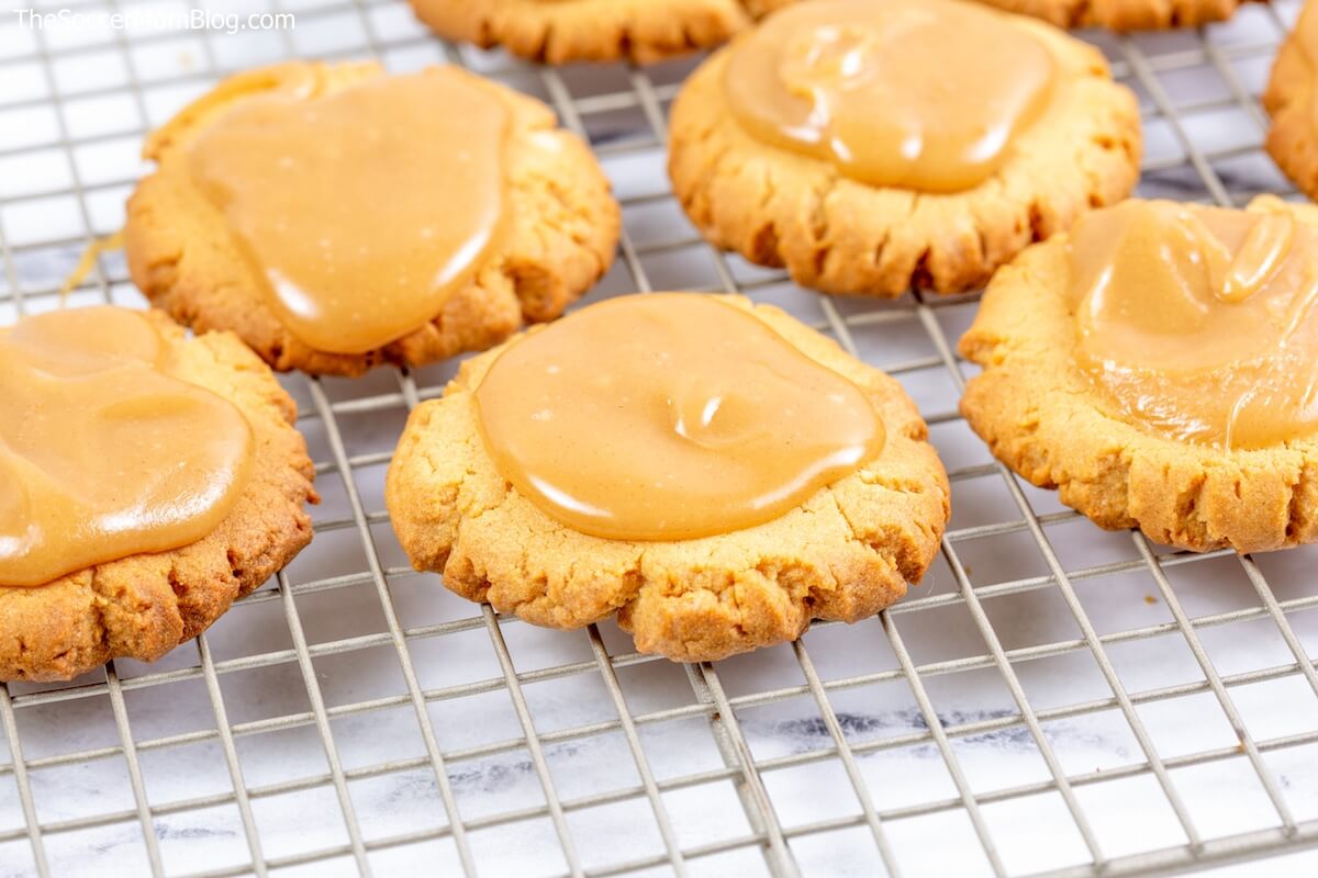 warm peanut butter cookies on wire rack with frosting