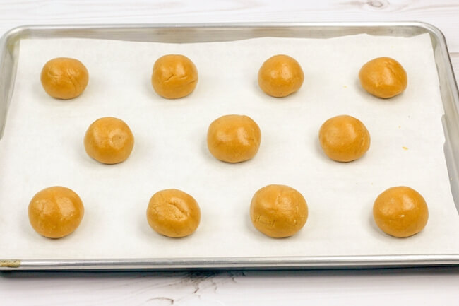 peanut butter cookie dough balls on baking sheet