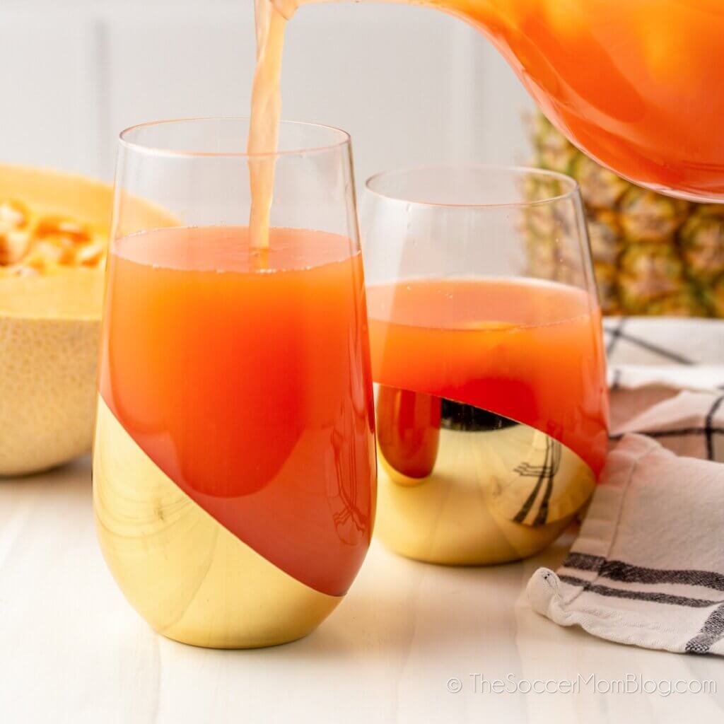 pouring rum punch into a glass