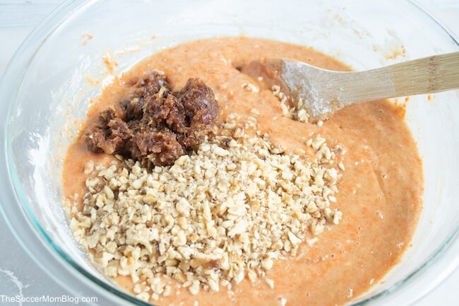 carrot cake batter in mixing bowl with chopped dates and nuts