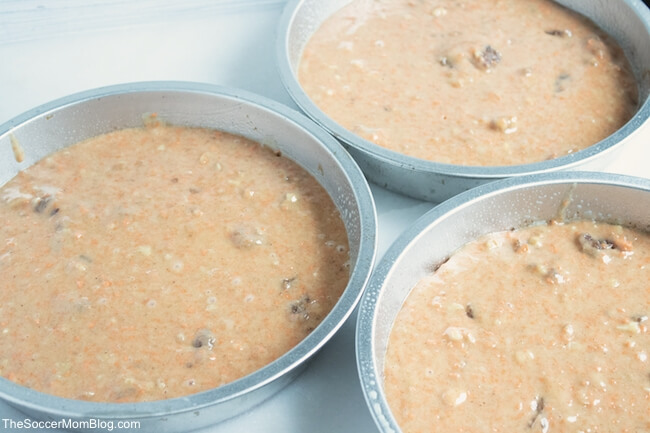3 round baking pans with carrot cake batter, uncooked