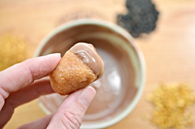 dipping donut holes into chocolate