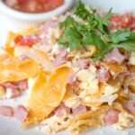 plate of migas, tortilla strips, eggs, and ham.