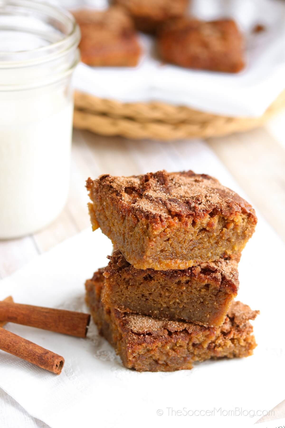 3 stacked chickpea blondies with cinnamon sticks and milk