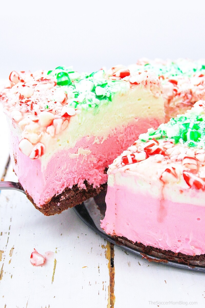taking a slice of peppermint cheesecake from the whole cake