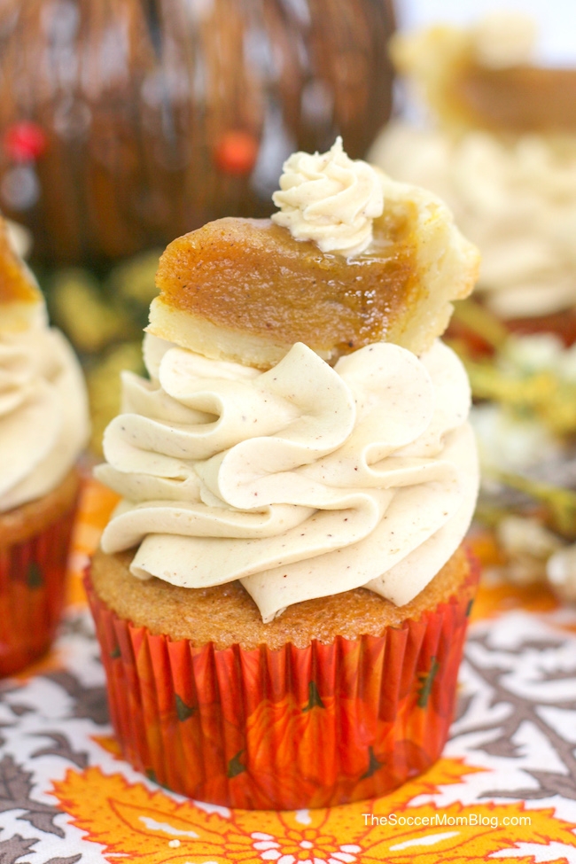 pumpkin spice cupcakes topped with cinnamon frosting and a mini pumpkin pie slice
