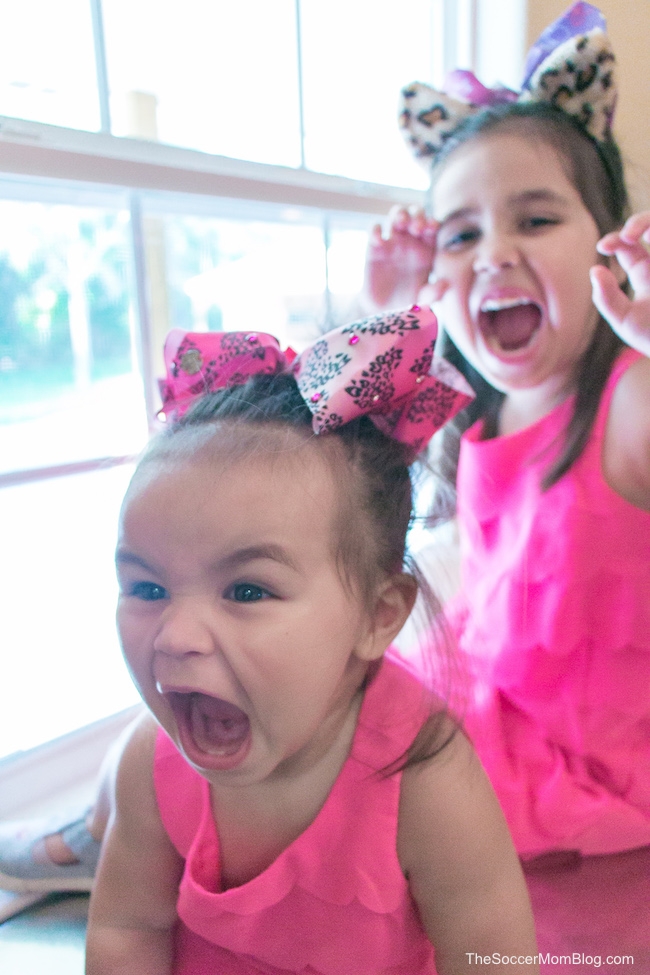 two little girls in pink dresses with fierce expressions