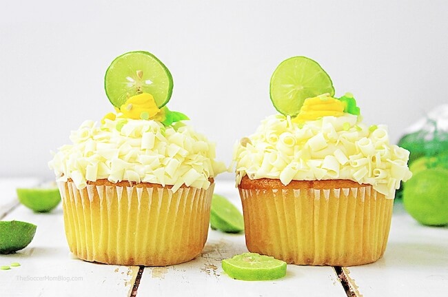 two key lime cupcakes surrounded by fresh limes
