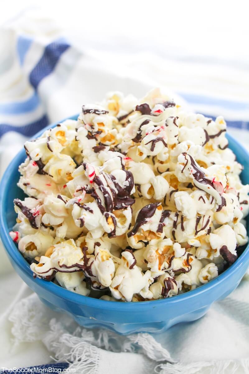 blue bowl with popcorn, drizzled with chocolate and crushed peppermint
