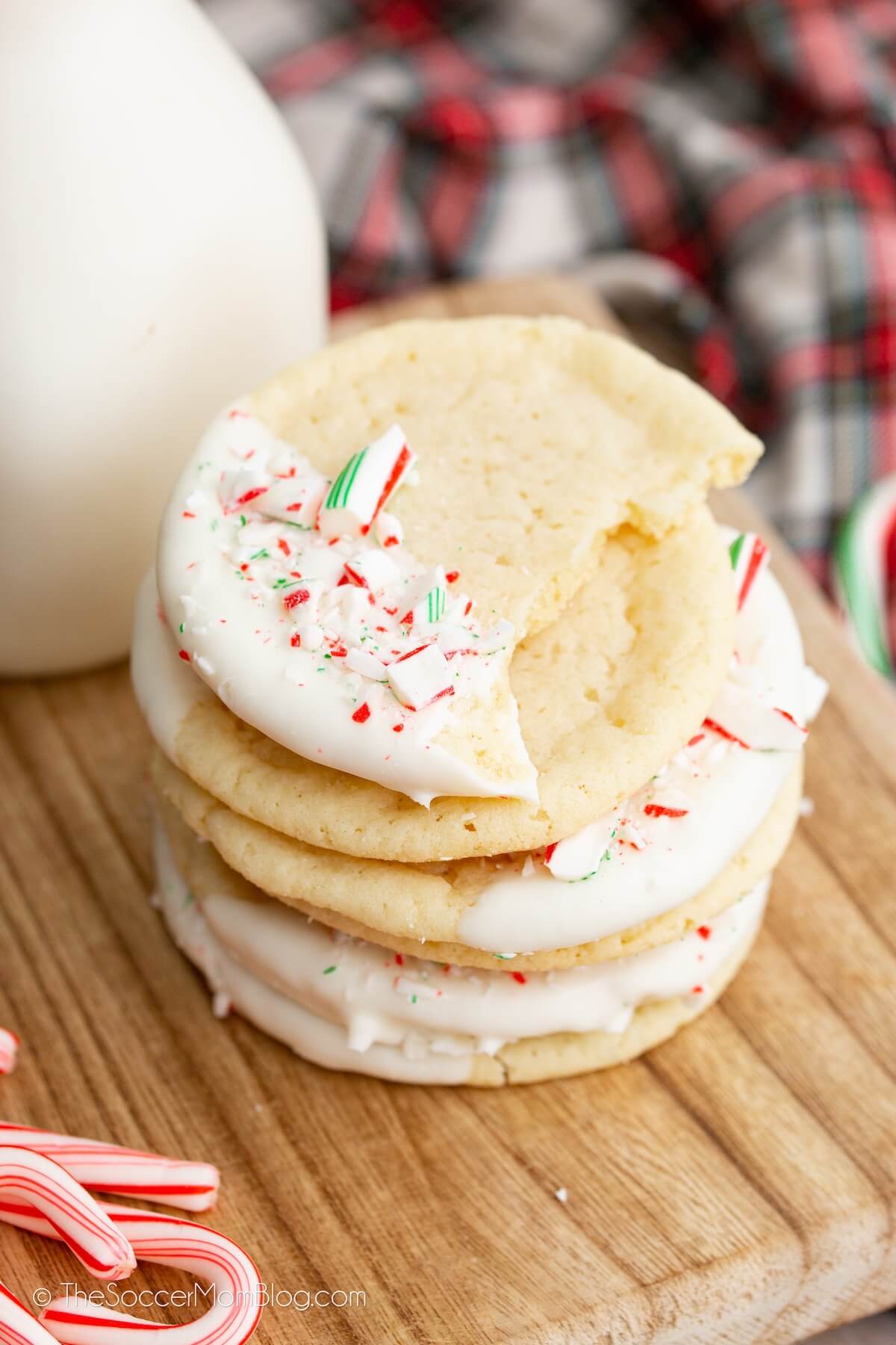 stack of sugar cookies, with a white chocolate coating and crushed peppermints on top