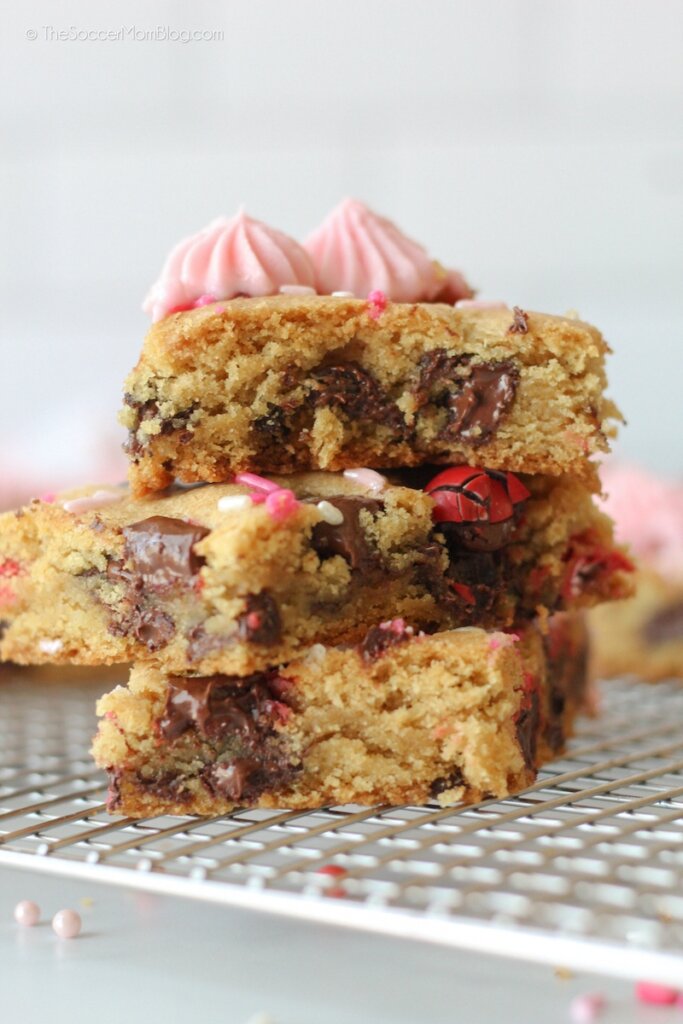 stack of chocolate chip cookie bars with pink frosting