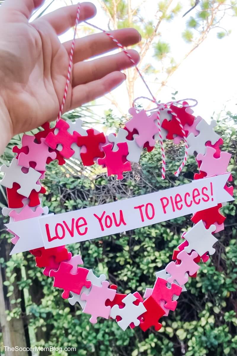 This adorable DIY Valentine Wreath is an easy and thrifty Valentine's Day craft to make with kids. All you need is a dollar store puzzle, a recycled cardboard box, and simple art supplies! 