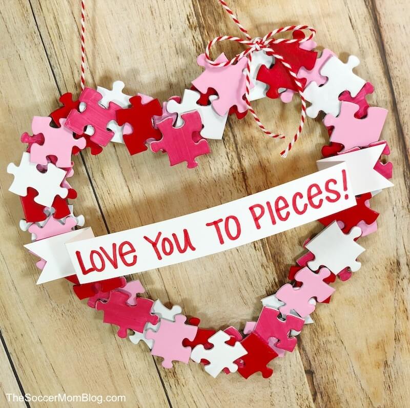 This adorable DIY Valentine Wreath is an easy and thrifty Valentine's Day craft to make with kids. All you need is a dollar store puzzle, a recycled cardboard box, and simple art supplies! 