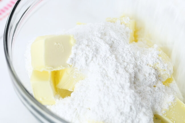 butter cubes and powdered sugar in mixing bowl