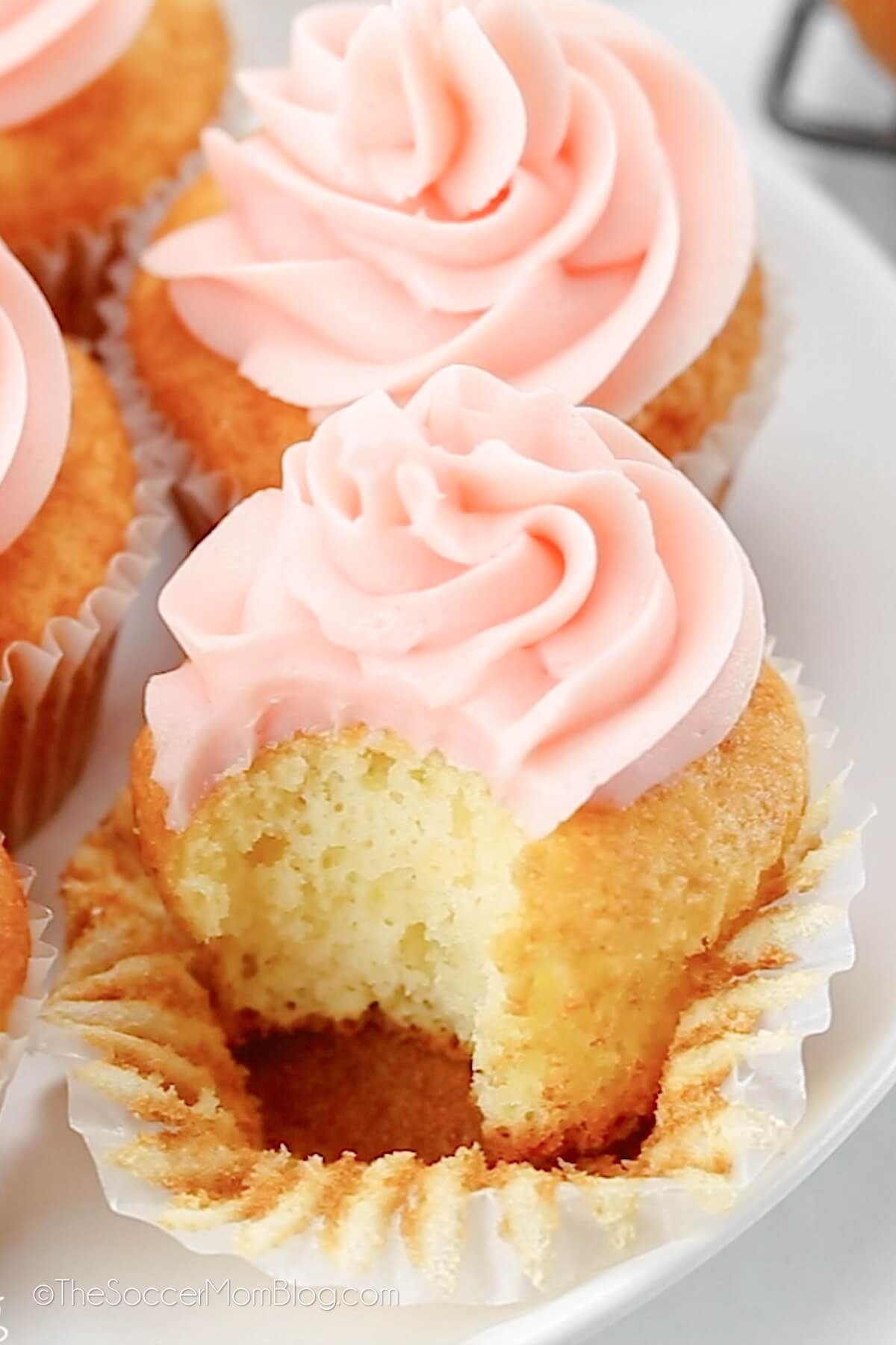 pink frosted cupcake with a bite taken.