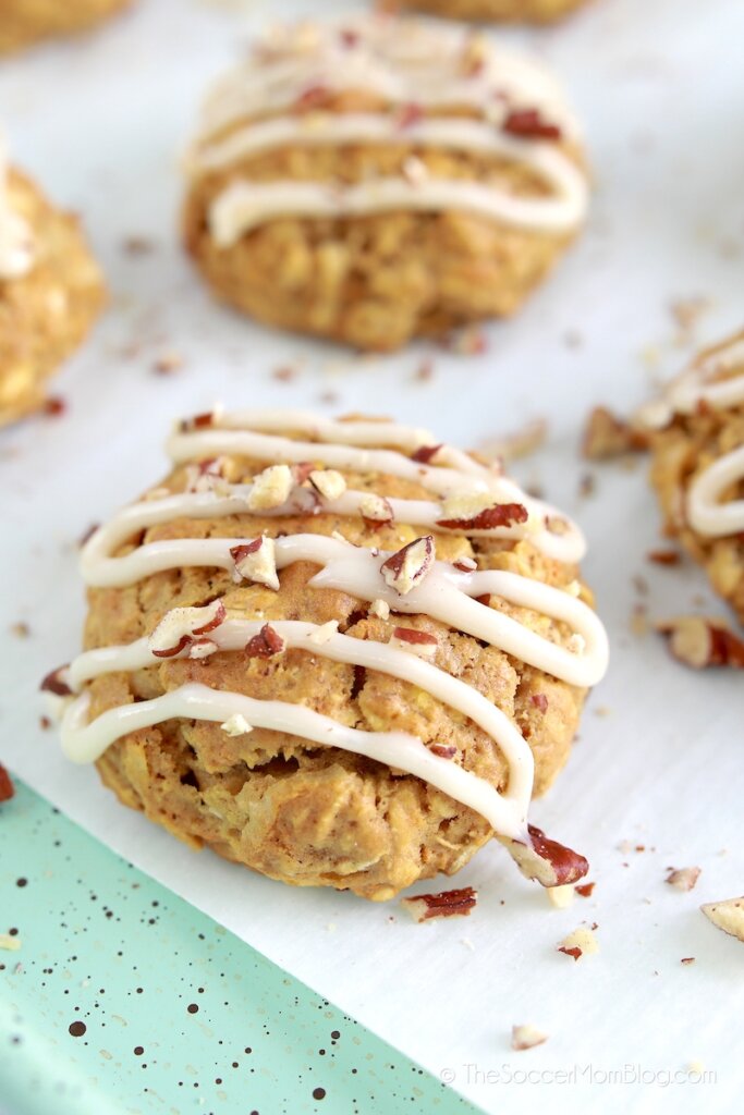 Carrot cake flavored cookies topped with frosting and chopped pecans