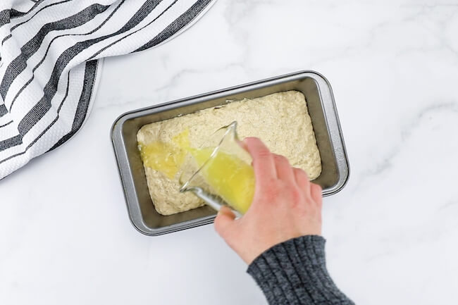 pouring melted butter in loaf pan