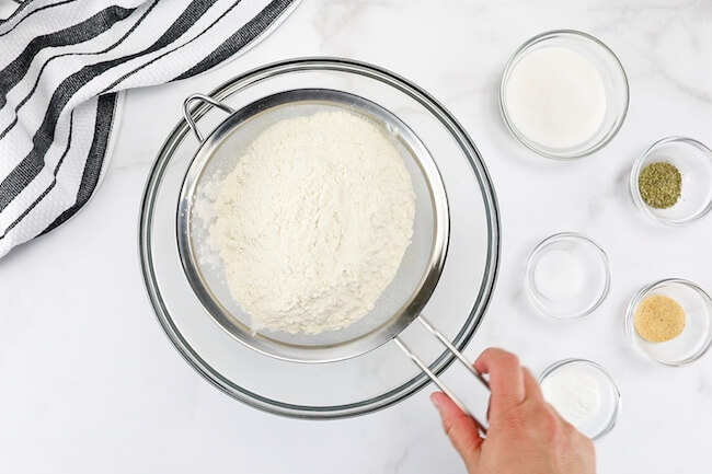 sifting flour into mixing bowl