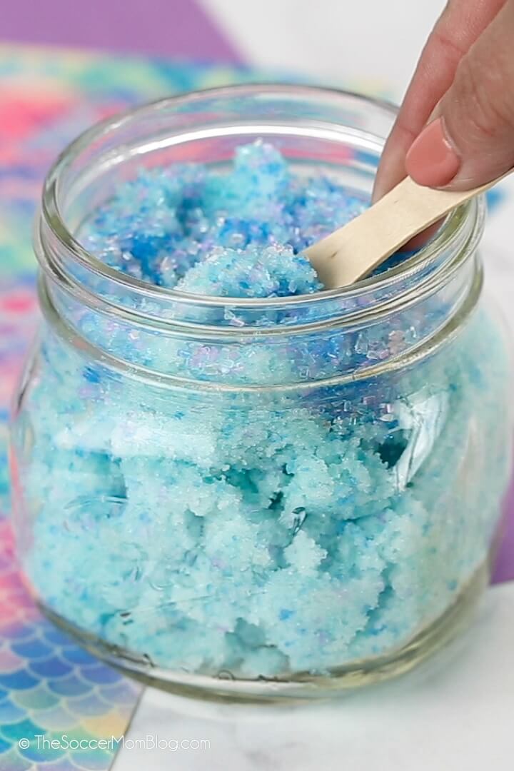 scooping homemade mermaid sugar scrub made with shimmery sprinkles