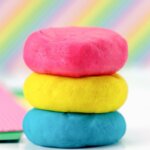 pink, yellow, and blue play dough with rainbow background