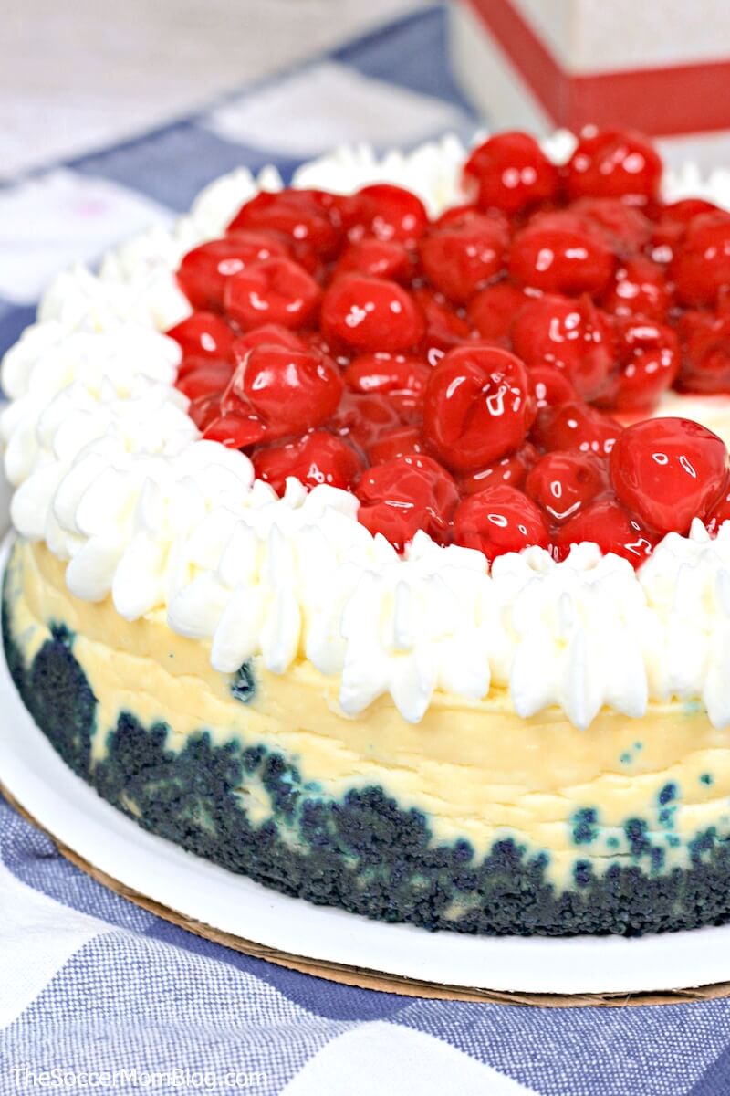 whole cheesecake with blue crust and cherry topping