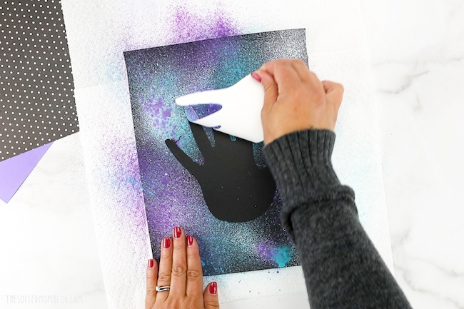 peeling back paper handprint for paint resist art
