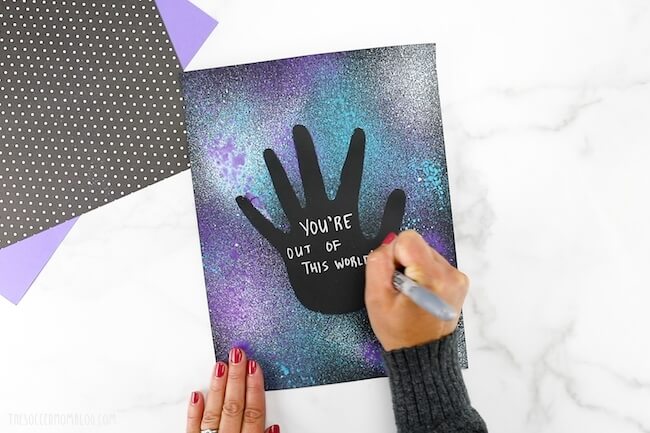 writing message on galaxy handprint art project