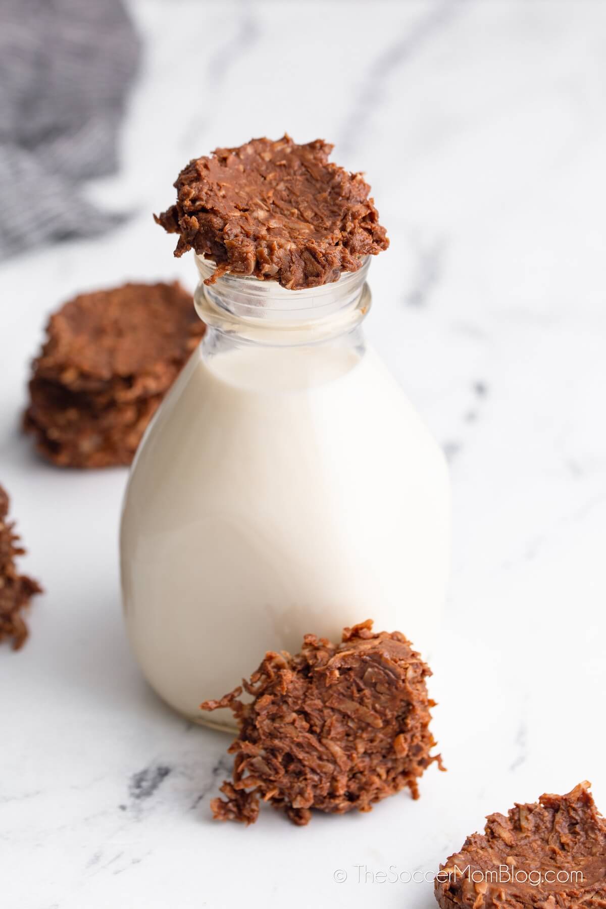 small jar of milk, with chocolate haystack cookies around it