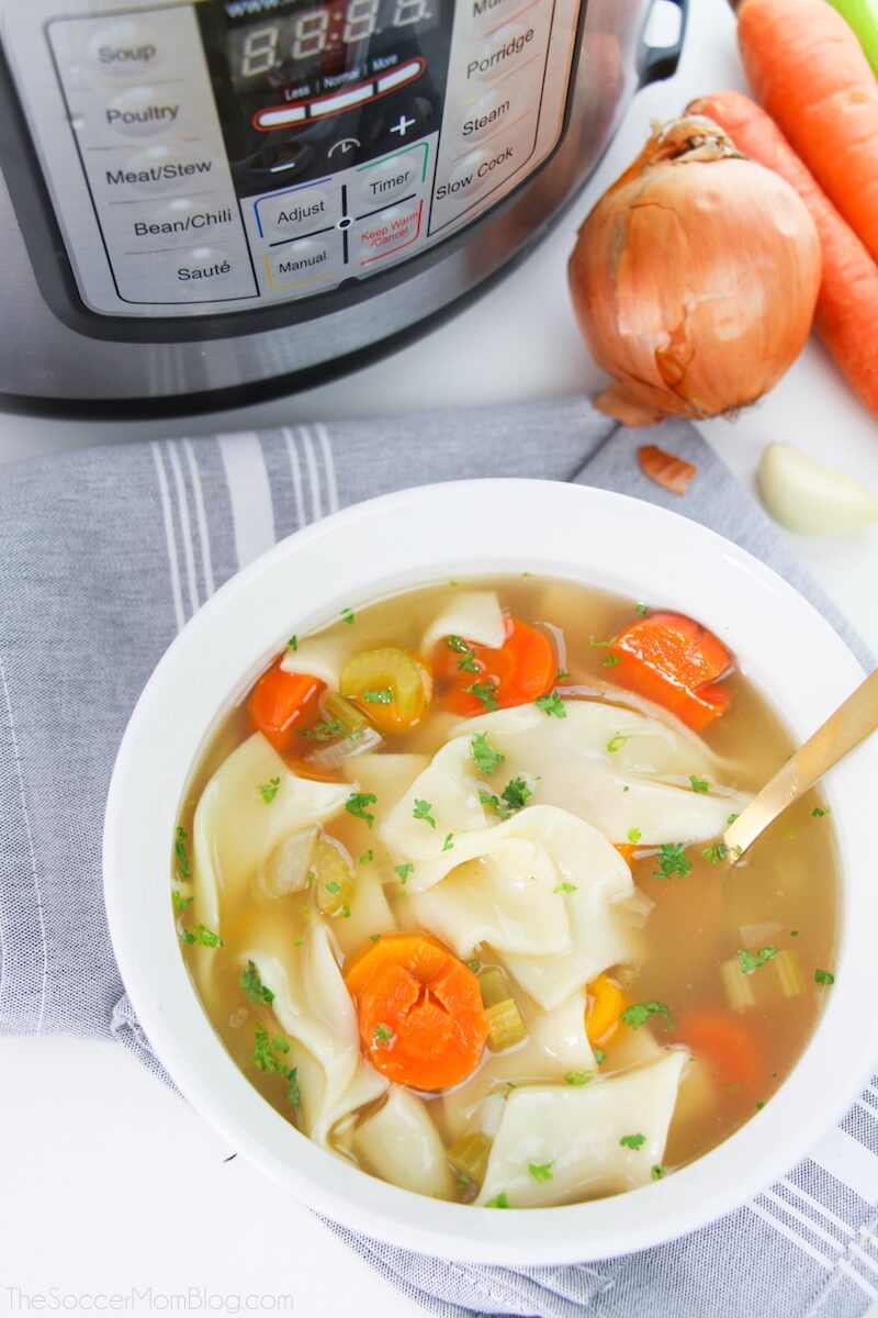 bowl of chicken noodle soup with Instant Pot in background