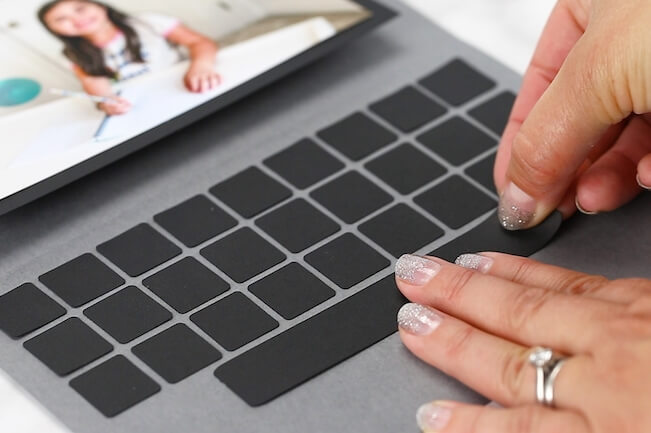 gluing black squares to make keys on a laptop card