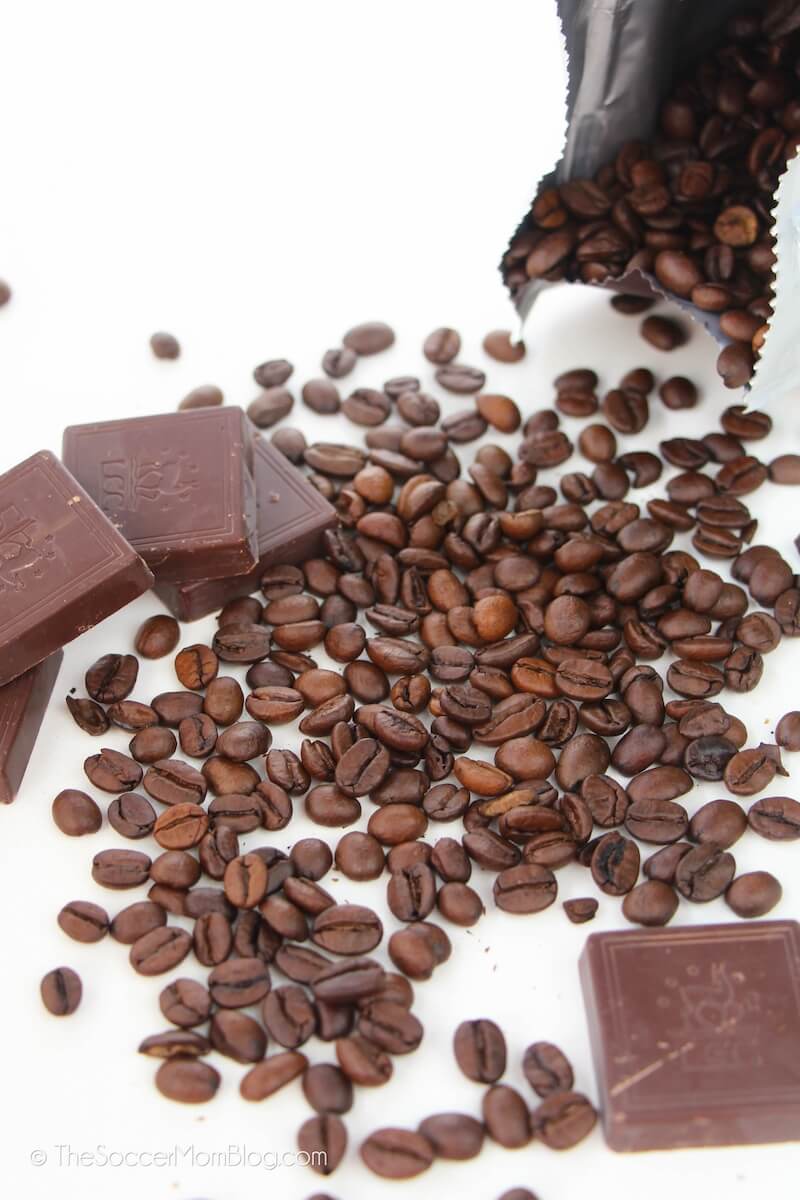 chocolate squares and whole roasted coffee beans on white background