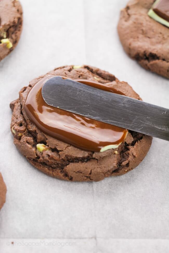 spreading melted chocolate on top of chocolate cookie