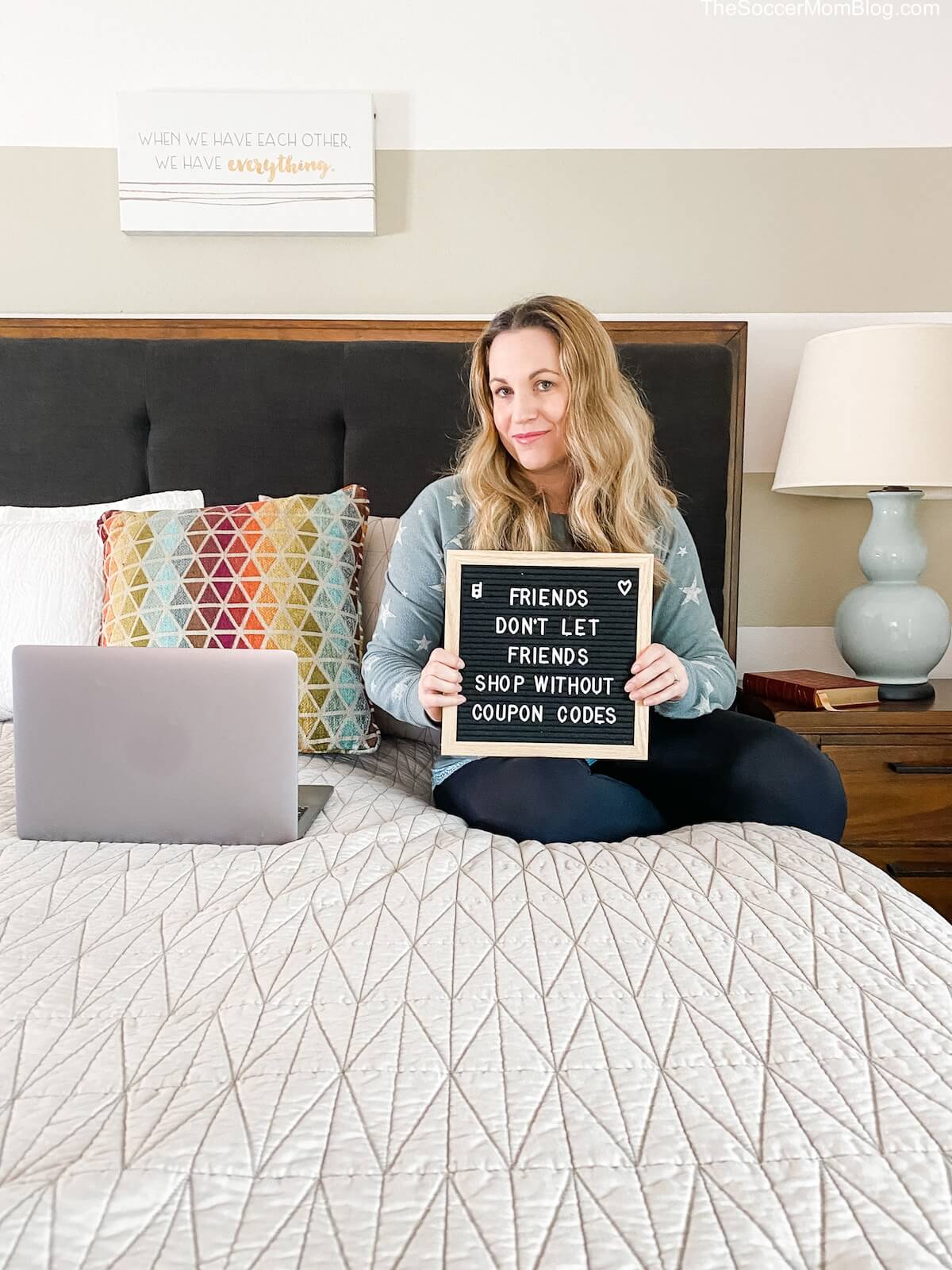 woman holding letter board sign about coupon codes