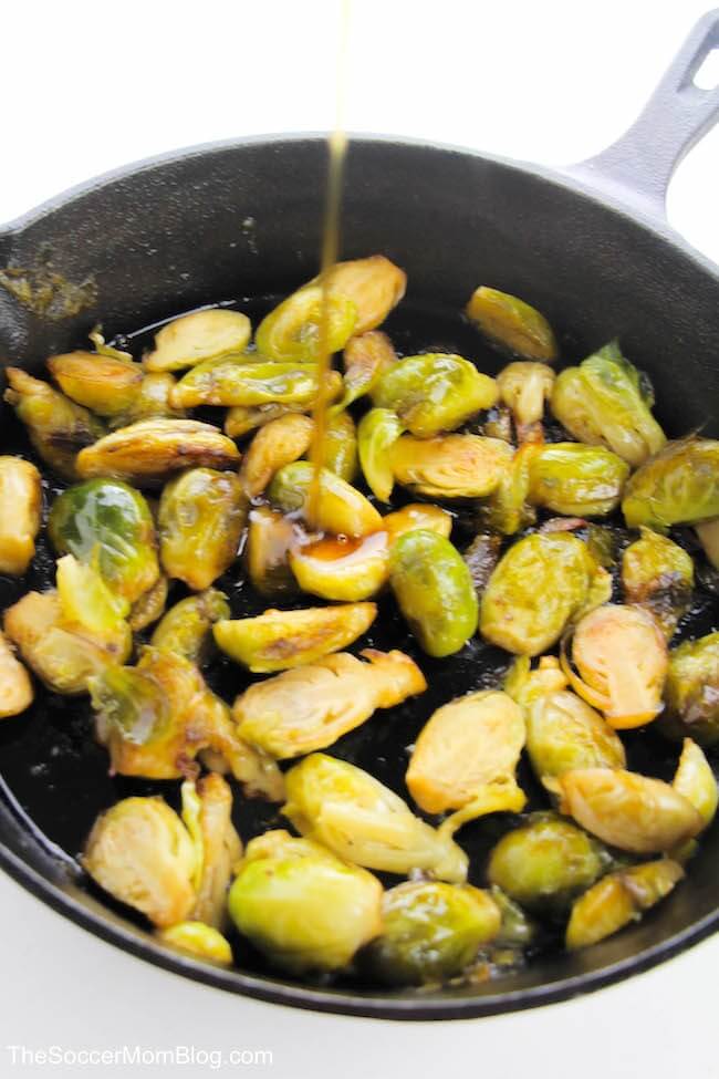 adding maple syrup to a pan of\ brussel sprouts