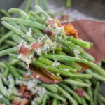 crisp roasted green beans on spatula with parmesan and bacon