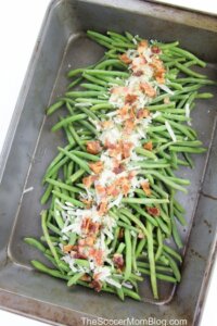 green beans in baking pan topped with parmesan cheese and bacon