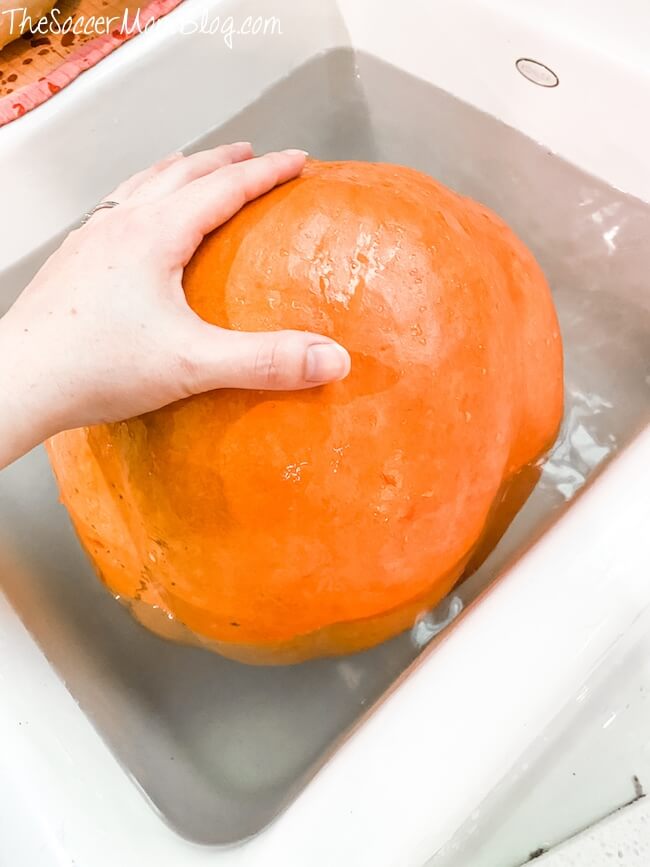 washing pumpkin in sink with vinegar