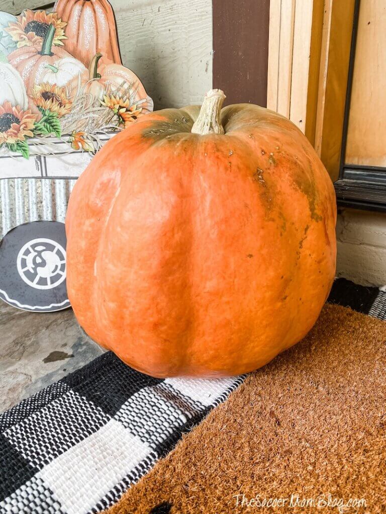 large orange uncarved pumpkin on front porch